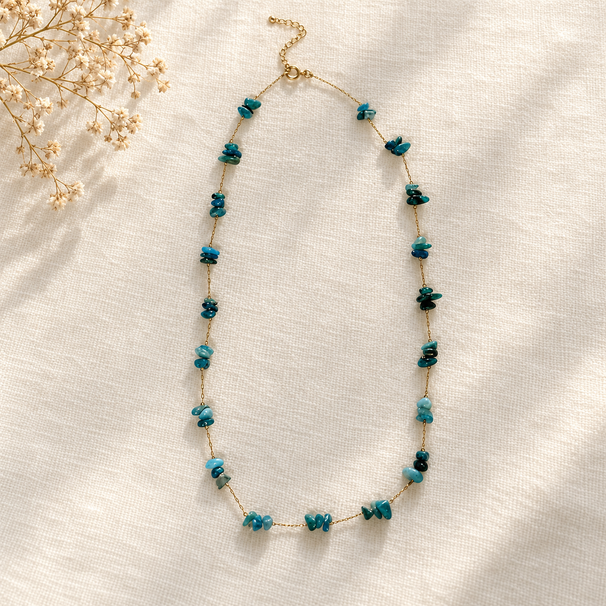 Goudkleurige ketting Azur Helderblauw met blauwgroene kralen op linnen