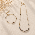Goudkleurige set Lune Smoke met ketting en armband op linnen