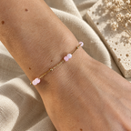 Goudkleurige armband Sola Lichtroze met roze steentjes om een pols