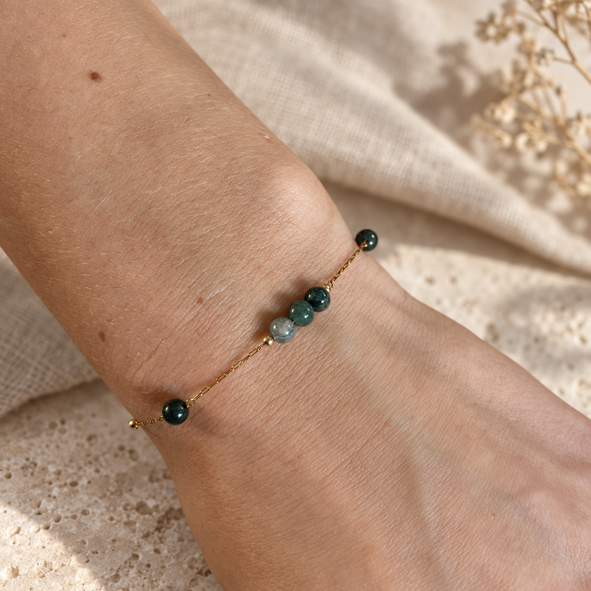 Goudkleurige armband Cala Mosgroen met groene kralen om een pols