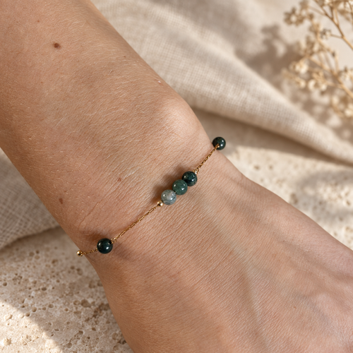 Goudkleurige armband Cala Mosgroen met groene kralen om een pols