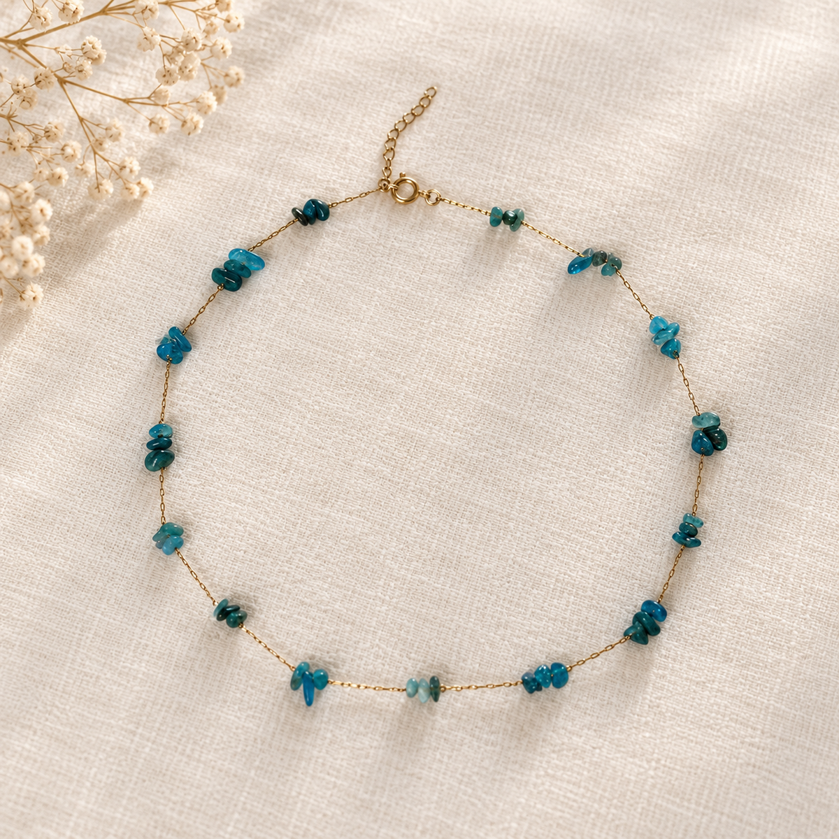 Goudkleurige ketting Azur Helderblauw op lichte stof