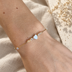 Goudkleurige armband Amora Blush met lichte kralen om een pols