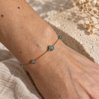 Goudkleurige armband Riva Oceaangroen om een pols