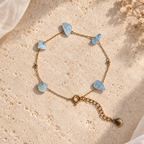 Goudkleurige armband Dune met lichtblauwe aquamarijn op een lichte steen