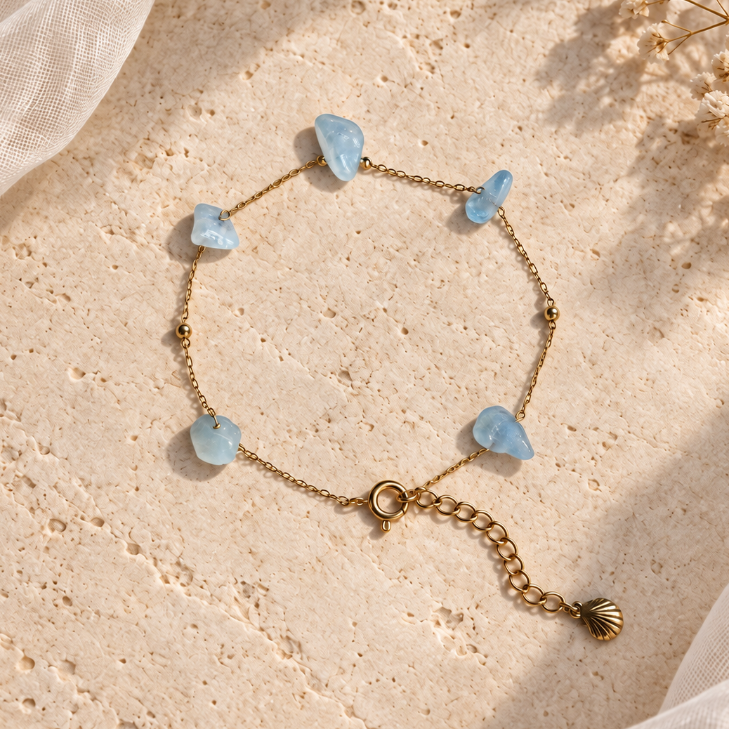 Goudkleurige armband Dune met lichtblauwe aquamarijn op een lichte steen
