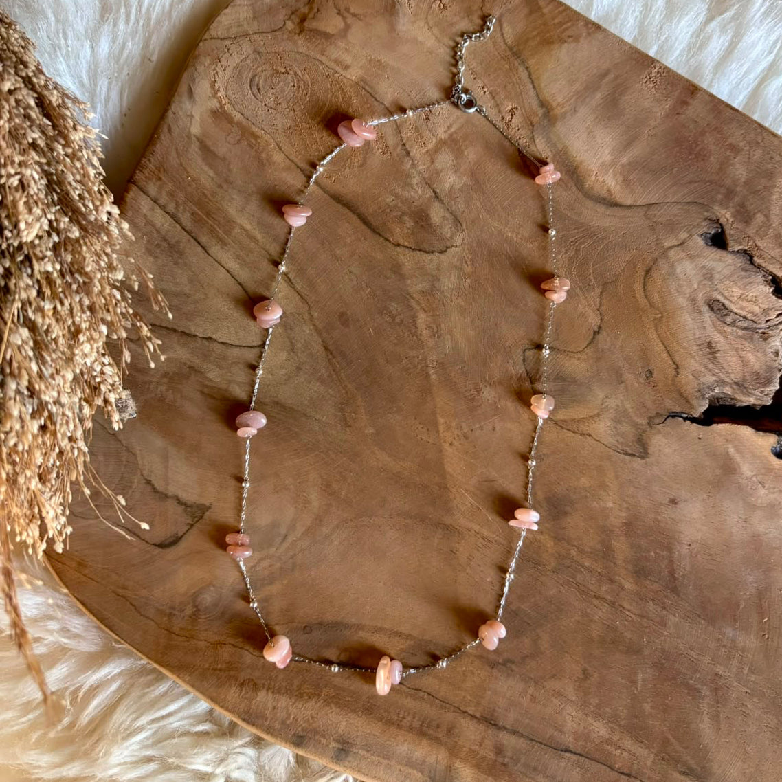 Lange zilverkleurige Lumi-ketting met roze maansteen op hout