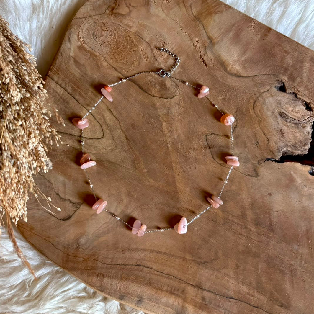 Korte zilverkleurige Lumi-ketting met roze maansteen op hout