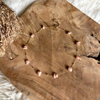 Korte goudkleurige Lumi-ketting met roze maansteen op hout