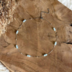 Zilverkleurige ketting Lumi met lichtblauwe aquamarijn op hout