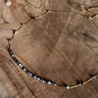 Grijze en donkere kraaltjes met gouden details van ketting Lune Smoke