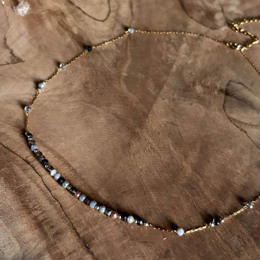 Grijze en donkere kraaltjes met gouden details van ketting Lune Smoke