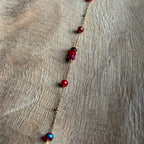 Close-up van Armband Cala Dieprood met goudkleurig details