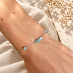 Close-up van zilverkleurige Armband Cala met facetgeslepen ijsblauwe natuursteen kraaltjes