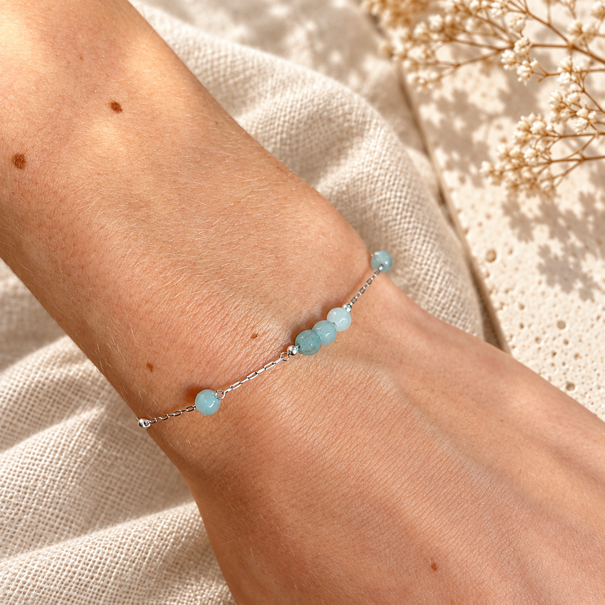 Close-up van zilverkleurige Armband Cala met facetgeslepen ijsblauwe natuursteen kraaltjes