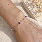 Armband Isla met paarse kraaltjes en goudkleurige details om de pols