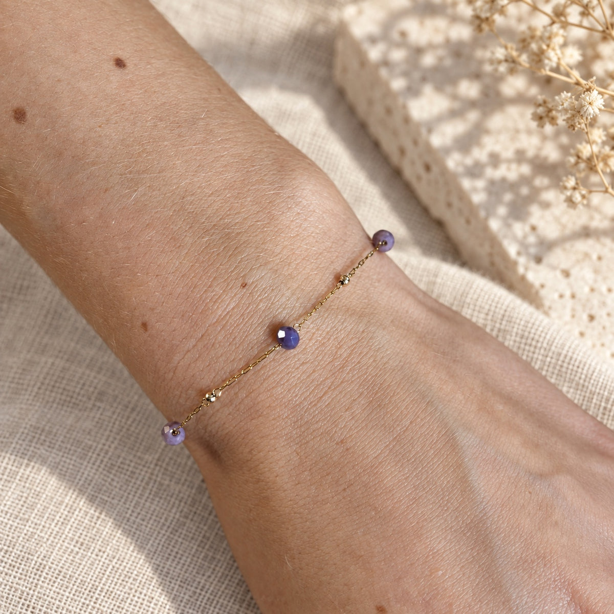 Armband Isla met paarse kraaltjes en goudkleurige details om de pols